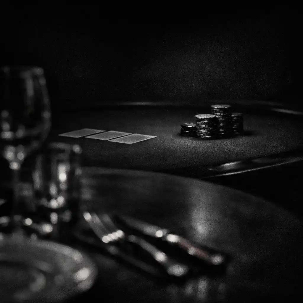 Dining table edge in the foreground with a softly blurred card-table setting beyond