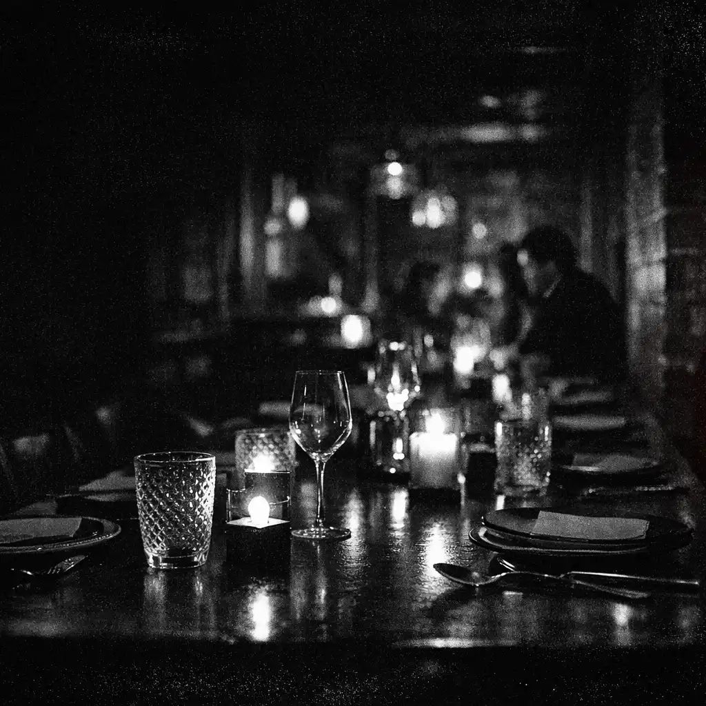 A dark ember-lit dining table inside Chance and Hearth